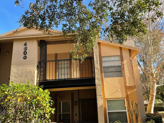 Front view of a two-story house with a balcony and visible building number.