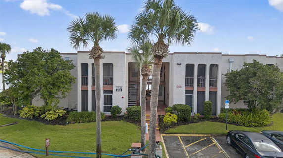 Front view of a two-story building with balconies and a central staircase.