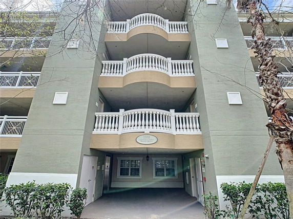 Front view of a multi-story building with balconies and arch-shaped railings.
