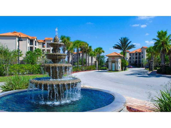 Front view of multi-story residential buildings with a central water fountain.