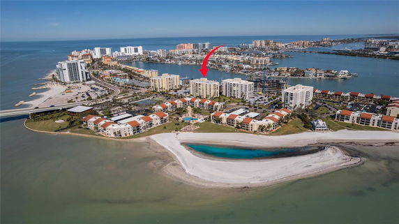 Aerial panoramic view of coastal buildings with beachfront and ocean in the background.