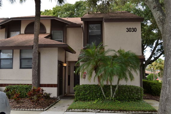 Front view of a two-story house with brown trim and a light-colored exterior.