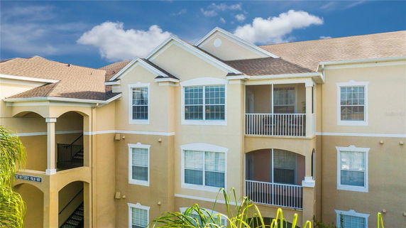 Front view of a multi-story residential building with balconies and large windows.