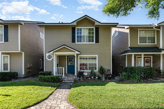Front view of a two-story house with a covered porch and a blue door.