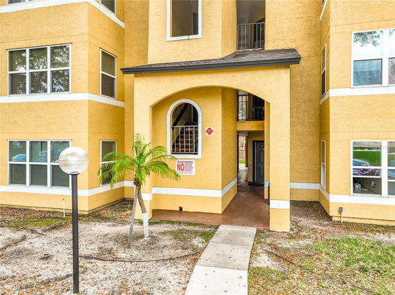 Front view of a multi-story apartment building with an entrance archway.