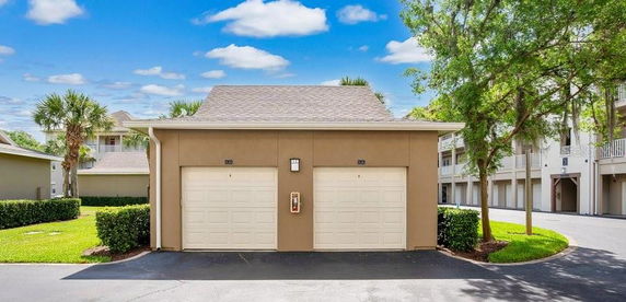 Covered parking area with two garage doors.