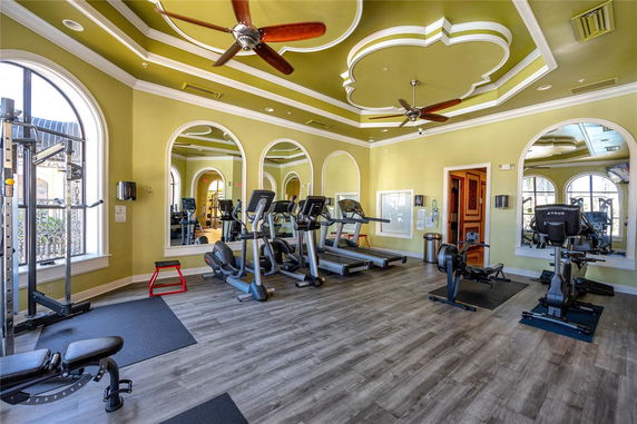 Interior view of a gym with exercise equipment and decorative ceiling.