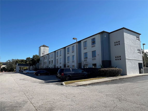 Front view of a multi-story building with parking area.