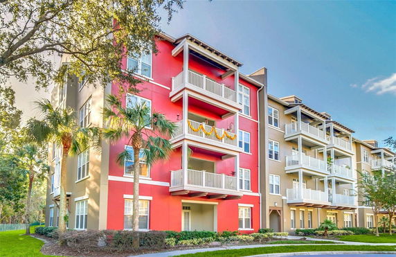 Front view of a multi-story apartment building with red and beige exteriors.