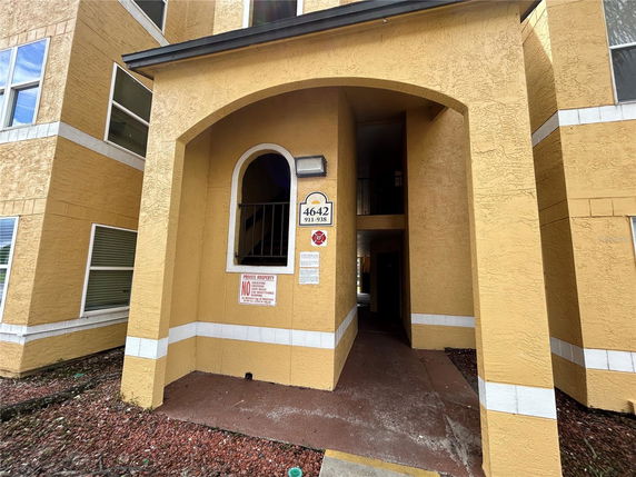 Front view of a multi-story building with yellow exterior.
