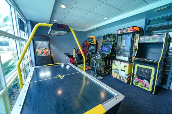 Indoor recreation area with arcade games and air hockey table.