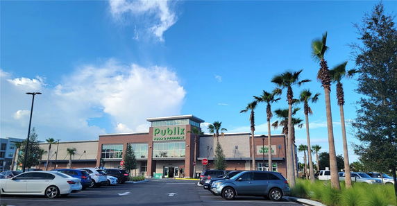 Front view of a large commercial building with a prominent entrance and parking area in front.