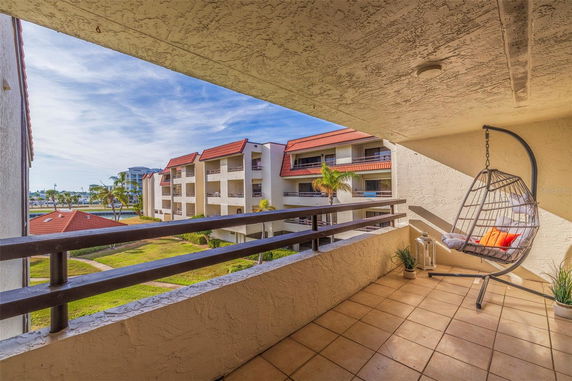 Panoramic view from a balcony showing nearby apartment buildings with red roofs.