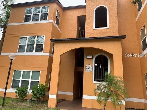 Front view of a multi-story apartment building with orange exterior walls and multiple windows.