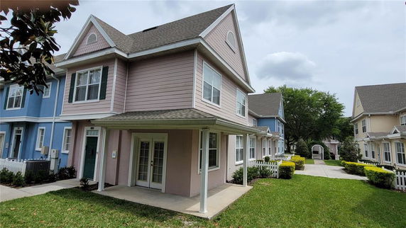 Front view of a two-story house with a covered entrance and multiple windows.