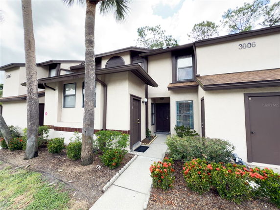Front view of a two-story building with brown trim and manicured landscaping.
