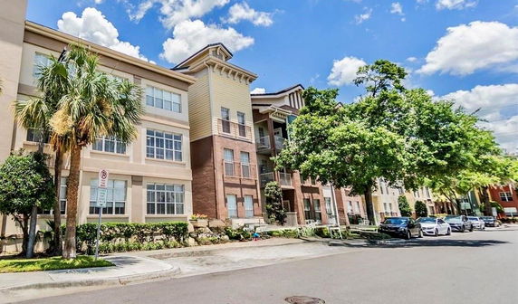 Front view of a multi-story residential building with large windows.