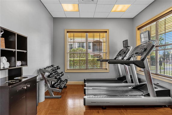 Indoor gym area with treadmills and dumbbells.