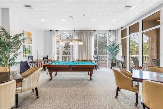 Indoor billiards room with pool table and seating area.