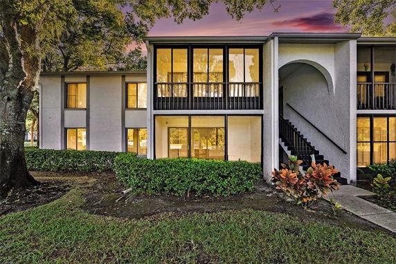 Front view of a two-story building with large windows and an external staircase.