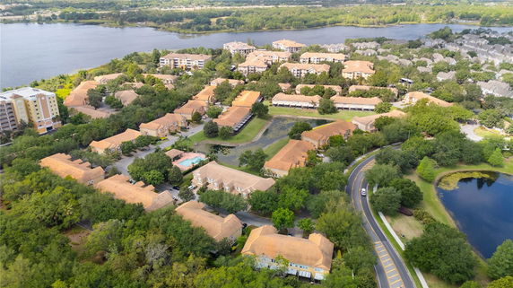 Panoramic view of a residential community with surrounding greenery and a body of water.
