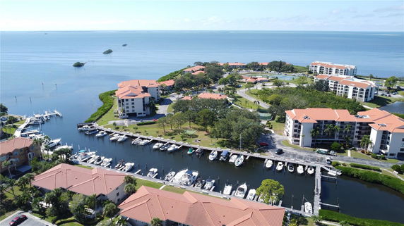 Aerial view of waterfront residential complex with multiple apartment buildings and a marina.