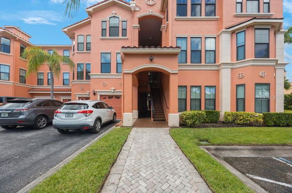 Front view of a multi-story building with a central entrance and parking area.