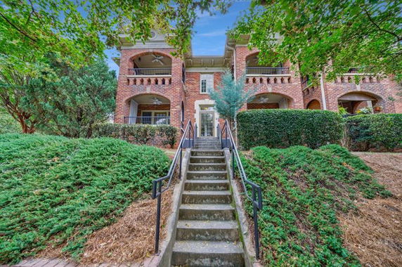 Front view of a two-story brick house with multiple arches and balconies.