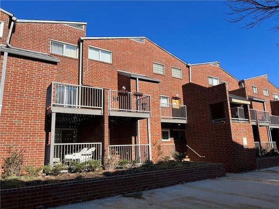 Front view of a multi-story brick building with balconies.