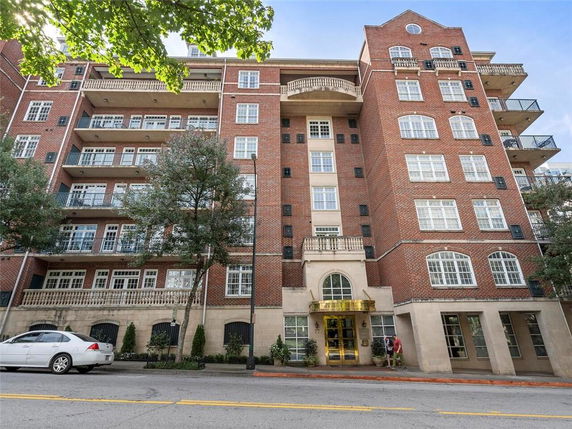 Front view of a multi-story brick building with balconies.