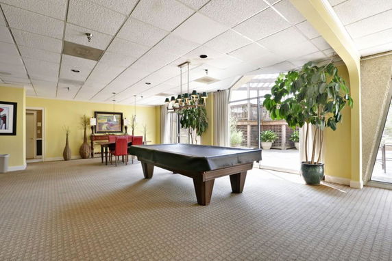Interior view of a recreation area with a billiards table and seating.