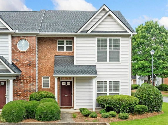 Front view of a two-story townhouse with brick and siding exterior.