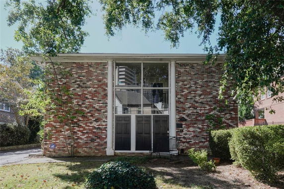 Front view of a two-story house with large windows and brick exterior.