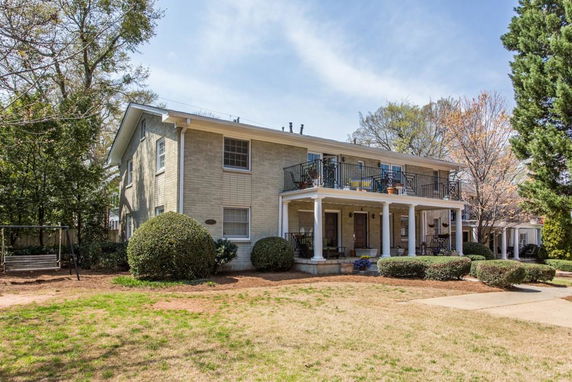 Front view of a two-story house with a balcony and porch.