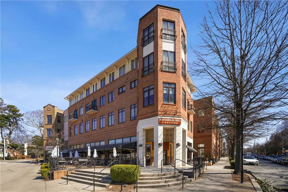 Front view of a multi-story brick building on a street corner.