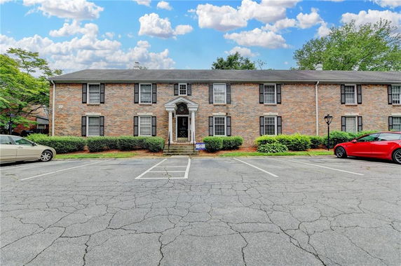 Front view of a two-story brick building with black shutters and a central entrance.