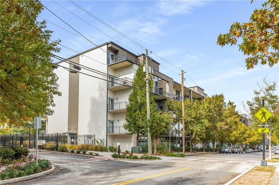 Front view of a modern multi-story apartment building with balconies.