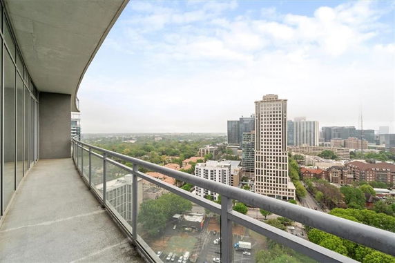 Panoramic view from a high-rise building balcony overlooking a cityscape.