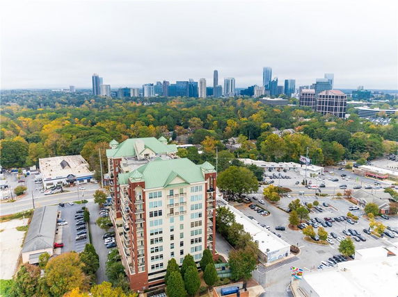 High-angle view of a cityscape featuring several multi-story buildings with a green-roofed building in the foreground.
