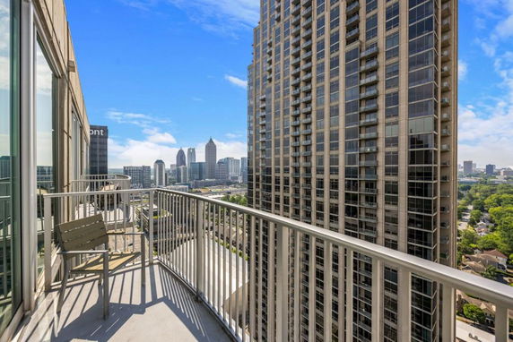 View from a high-rise balcony overlooking a city skyline with tall buildings.