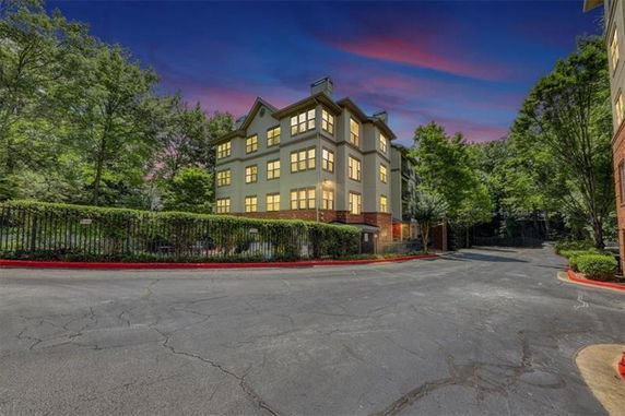 Front view of a multi-story building with a gated entrance.