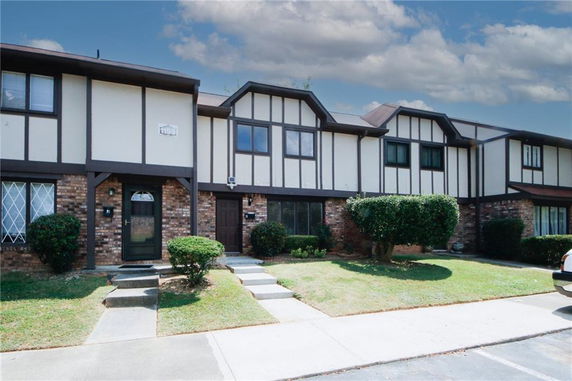 Front view of a two-story townhouse with brick and paneled exterior.