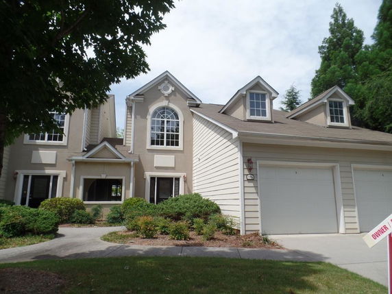Front view of a two-story house with a double garage and arched window.