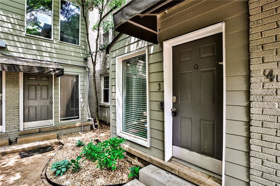 Front view of a multi-level house with multiple doors.
