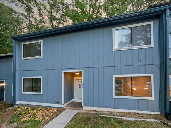 Front view of a two-story blue house with multiple windows and a white door.