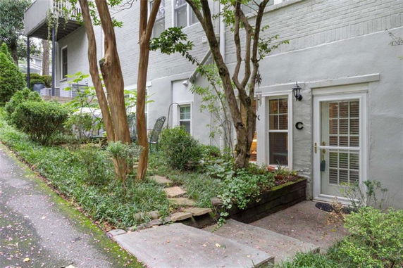 Front view of a lower-level residential entrance with double glass doors.