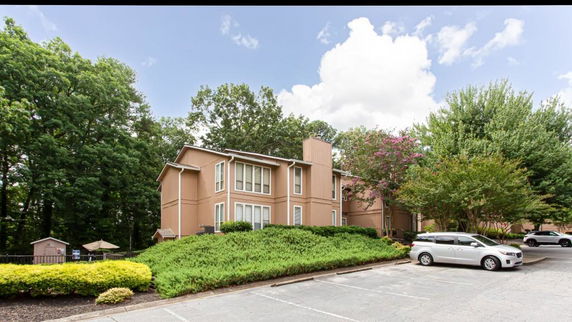 Front view of a two-story building with parking area.
