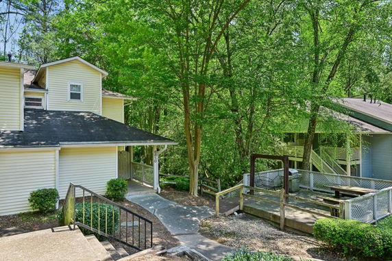 Front view of a two-story house with a sloped roof and a path leading to the entrance.