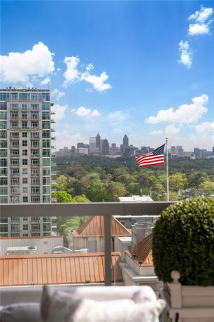 Panoramic view of a cityscape with tall buildings and an American flag in the foreground.
