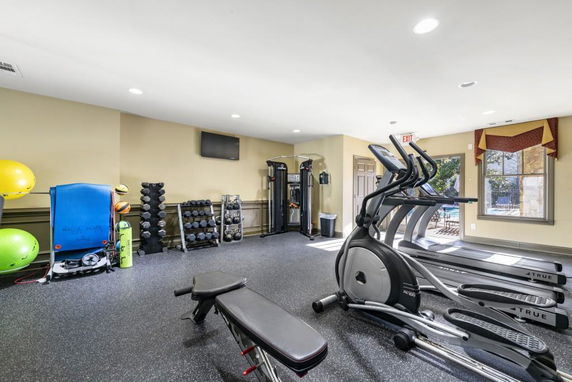 Indoor gym area with exercise equipment including treadmills, weights, and workout machines.